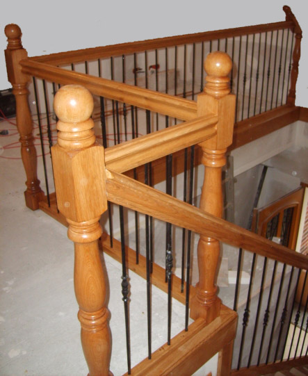 Escalier avec un garde-corps en bois et fer forgé.